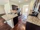 Well-equipped kitchen boasts granite countertops, stainless steel appliances, and dark cabinetry at 1291 Vienna Ct, Hampton, GA 30228