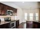 Bright kitchen featuring stainless steel appliances, dark cabinets, and granite countertops at 1291 Vienna Ct, Hampton, GA 30228