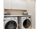 Functional laundry room featuring ample cabinet space, a folding counter, and modern appliances at 230 Society St, Alpharetta, GA 30022