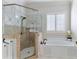 Relaxing main bathroom featuring a soaking tub and a large tile and glass shower enclosure at 230 Society St, Alpharetta, GA 30022