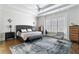Spacious main bedroom featuring a tray ceiling, ceiling fan, and a sitting area at 230 Society St, Alpharetta, GA 30022