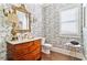 Charming powder room with decorative wallpaper, an antique vanity, and hardwood floors at 230 Society St, Alpharetta, GA 30022
