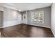 Bright living room featuring hardwood flooring, a large window, and white wainscoting for a cozy atmosphere at 620 Dahoma Trl, Woodstock, GA 30188