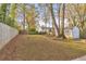 Spacious backyard with a large grassy area, wooden fence, storage shed, and mature trees at 1591 Alder Se Ct, Atlanta, GA 30317