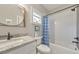 Well-lit bathroom with granite countertop, round mirror, tub, shower, and decorative blue curtain at 1591 Alder Se Ct, Atlanta, GA 30317