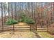 Backyard view with a wood fence and a grassy area in a wooded setting at 2557 Sixes Rd, Canton, GA 30114