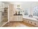 Spa-like bathroom with a soaking tub, a stand-up shower with a bench, stained glass windows, and dual vanities at 2557 Sixes Rd, Canton, GA 30114