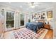 Cozy bedroom with built-in shelving, hardwood floors, three windows and a colorful area rug at 2557 Sixes Rd, Canton, GA 30114