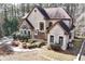 View of the house with a blend of stone and stucco finishes, and landscaped front yard at 2557 Sixes Rd, Canton, GA 30114