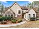 Charming home featuring a stone facade, arched windows, manicured landscaping, and a welcoming walkway at 2557 Sixes Rd, Canton, GA 30114