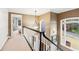 Upstairs hallway features an arched window letting in natural light and an ornamental chandelier at 2557 Sixes Rd, Canton, GA 30114