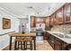 Well-lit kitchen featuring stainless steel appliances, dark wood cabinets, and a cozy breakfast bar with seating at 2557 Sixes Rd, Canton, GA 30114