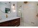 Elegant bathroom featuring a wood vanity, marble countertop, frameless shower, and contemporary fixtures at 2569 Woodhill Ln, Atlanta, GA 30344