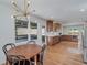 Inviting dining area open to kitchen with backyard views, hardwood floors, modern light fixture and custom cabinets at 2569 Woodhill Ln, Atlanta, GA 30344