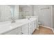 Bathroom featuring double sinks, white cabinetry, and a separate glass-enclosed shower at 6491 Stonelake Sw Pl, Atlanta, GA 30331