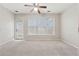 Spacious carpeted bedroom with a ceiling fan, and a view to the outside at 6491 Stonelake Sw Pl, Atlanta, GA 30331