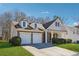 Inviting two-story house with a manicured lawn and attached two-car garage, exuding curb appeal at 6491 Stonelake Sw Pl, Atlanta, GA 30331