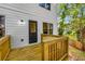 Wooden deck and railing with backyard access, attached to a white home with a black door at 891 Thurmond Nw St, Atlanta, GA 30314