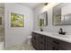 Bright bathroom featuring double sinks, gray cabinets, quartz countertops, and a window with natural light at 891 Thurmond Nw St, Atlanta, GA 30314