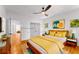 Brightly staged bedroom featuring hardwood floors, ceiling fan, and a comfortable queen-sized bed with yellow bedding at 891 Thurmond Nw St, Atlanta, GA 30314