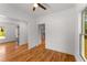 Bedroom with hardwood floors, ceiling fan, white walls, and view into another room with a window at 891 Thurmond Nw St, Atlanta, GA 30314