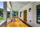 A cozy front porch boasts a wooden floor, crisp white columns, and a welcoming wood door at 891 Thurmond Nw St, Atlanta, GA 30314