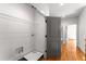 Hallway with hardwood floors, laundry room with wire shelving, and gray painted doors at 891 Thurmond Nw St, Atlanta, GA 30314