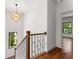 Bright hallway with modern chandelier, showcasing hardwood floors and staircase with decorative white railing at 891 Thurmond Nw St, Atlanta, GA 30314