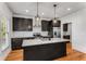 Open kitchen view with granite island, dark wood cabinets, stainless appliances, and hardwood floors at 891 Thurmond Nw St, Atlanta, GA 30314