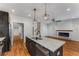 Open kitchen featuring a granite island, stainless steel appliances, and hardwood floors that flow into a living room with fireplace at 891 Thurmond Nw St, Atlanta, GA 30314