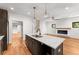 Open kitchen featuring a granite island, stainless steel appliances, and hardwood floors that flow into a living room with fireplace at 891 Thurmond Nw St, Atlanta, GA 30314