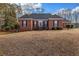 Charming red brick home with a dark roof, set on a spacious lawn with mature trees and manicured bushes at 1450 Brandy Shoals Se Dr, Conyers, GA 30013