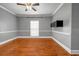 Living room features hardwood floors, light-colored walls, a ceiling fan, and a large window for natural light at 1450 Brandy Shoals Se Dr, Conyers, GA 30013