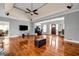 Open living room with hardwood floors, high ceilings, a large TV, and views into other areas of the home at 1450 Brandy Shoals Se Dr, Conyers, GA 30013