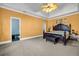 Spacious main bedroom with a tray ceiling, carpeted floor, and ensuite bath entrance at 1450 Brandy Shoals Se Dr, Conyers, GA 30013