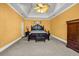 Main bedroom featuring carpet floors, yellow walls, ceiling fan, wardrobe, and night tables at 1450 Brandy Shoals Se Dr, Conyers, GA 30013