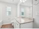 Bathroom featuring granite counters, white cabinets, natural light, and modern fixtures at 2025 Wyndham Pl, Conyers, GA 30013
