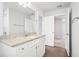Bathroom featuring granite counters, white cabinets, natural light, and modern fixtures at 2025 Wyndham Pl, Conyers, GA 30013