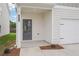 Two-story home's entrance and garage, with manicured landscaping at 2025 Wyndham Pl, Conyers, GA 30013