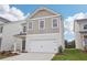 A two-story home with a two-car garage, and a well manicured front yard at 2025 Wyndham Pl, Conyers, GA 30013