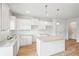 Bright kitchen features white cabinets, granite counters, a center island, stainless steel sink and wood-look flooring at 2025 Wyndham Pl, Conyers, GA 30013