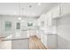 Bright kitchen features white cabinets, granite counters, a center island, stainless steel sink, and an exterior door at 2025 Wyndham Pl, Conyers, GA 30013