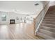 Open-concept living room with a fireplace and staircase, leading to the kitchen at 2025 Wyndham Pl, Conyers, GA 30013