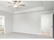 Spacious primary bedroom featuring a ceiling fan, trey ceiling, carpet and two windows offering natural light at 2025 Wyndham Pl, Conyers, GA 30013