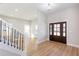 Bright entryway with wood floors, stylish light fixture and staircase with black iron balusters at 3286 Bachelor St, East Point, GA 30344