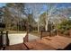 Backyard with a wooden deck, steps leading to a concrete patio, and mature trees at 4837 Mystere Cir, Lilburn, GA 30047