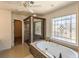 Bright bathroom featuring a standalone tub beneath a decorative window and glass shower at 4837 Mystere Cir, Lilburn, GA 30047