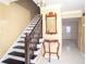 Inviting foyer features a staircase with dark wood steps and a decorative table with mirror at 4837 Mystere Cir, Lilburn, GA 30047