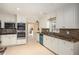 Well-lit kitchen with white cabinets, stainless steel appliances, and an adjacent breakfast area at 4837 Mystere Cir, Lilburn, GA 30047