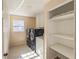 Bright laundry room with modern washer and dryer, storage cabinets, and shelving at 4837 Mystere Cir, Lilburn, GA 30047